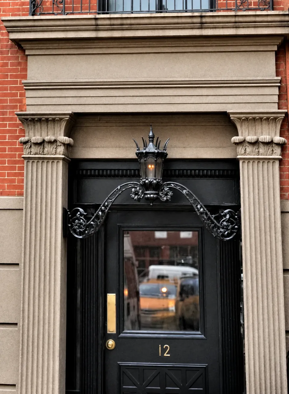 The entrance surround at No. 12, with fluted pilasters and Egyptian-influenced capitals.