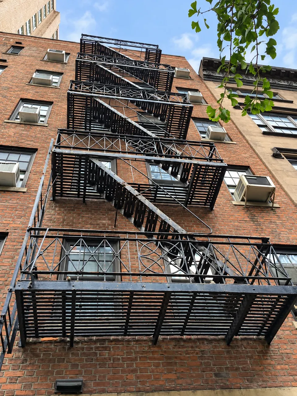 The exposed iron fire escape rising across the brick facade of 17 Gramercy Park South.