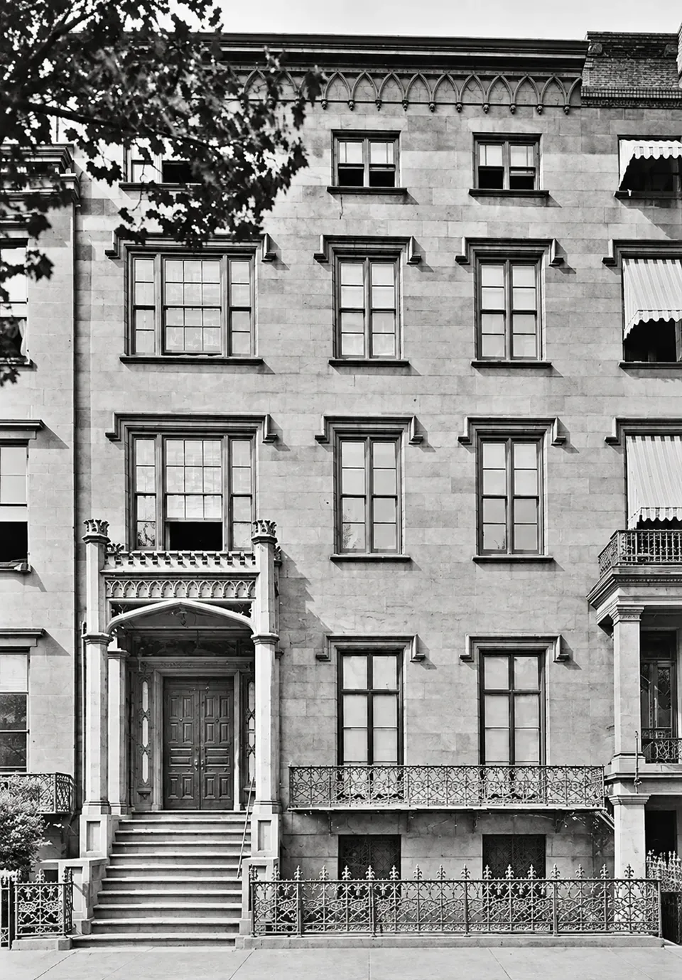 The lost Gerard house, with a high stoop, Gothic entrance, pointed-arch cornice decoration, and iron balcony.