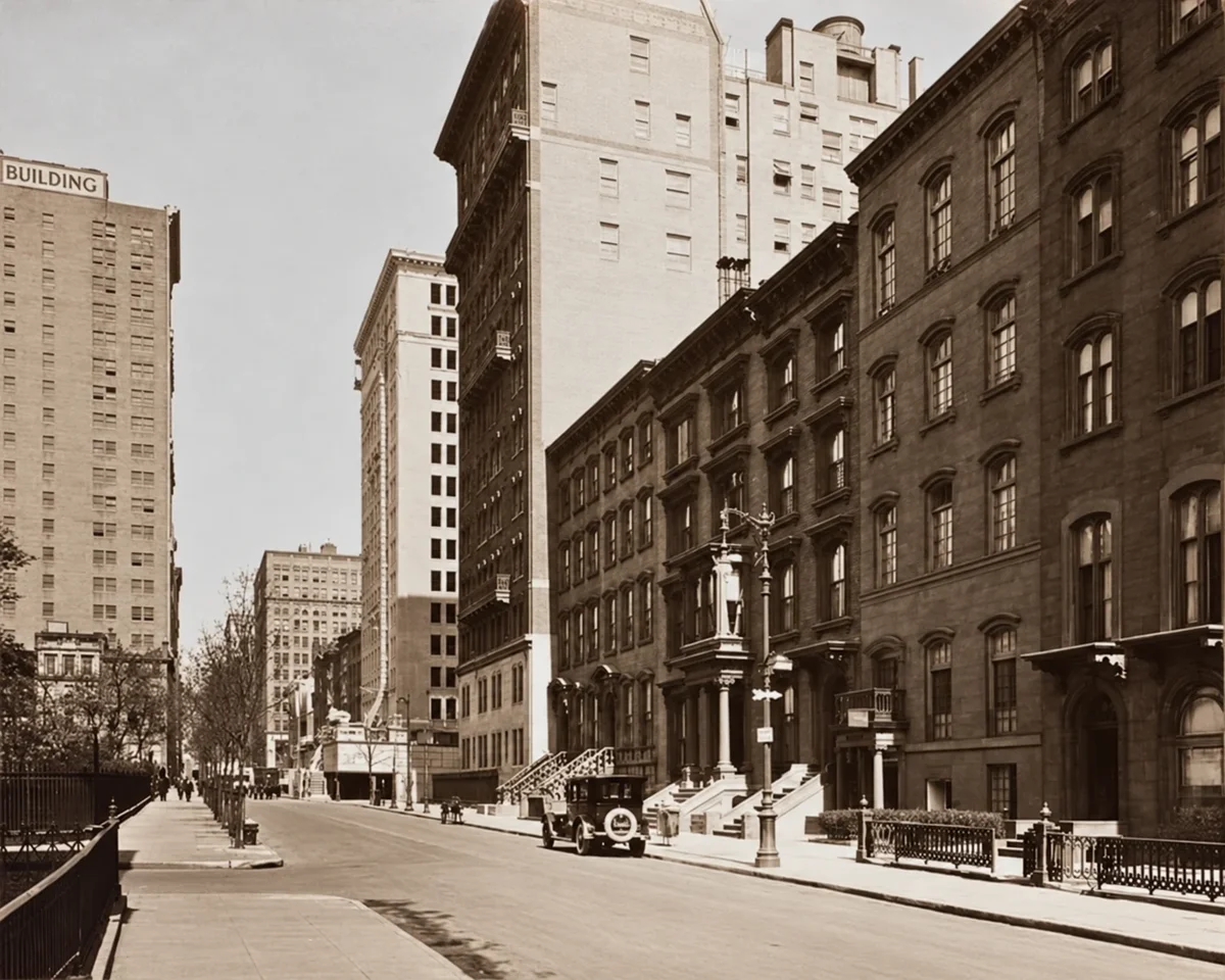 Looking west along Gramercy Park North in April 1925, with row houses and stoops on the right and the Park fence on the left.