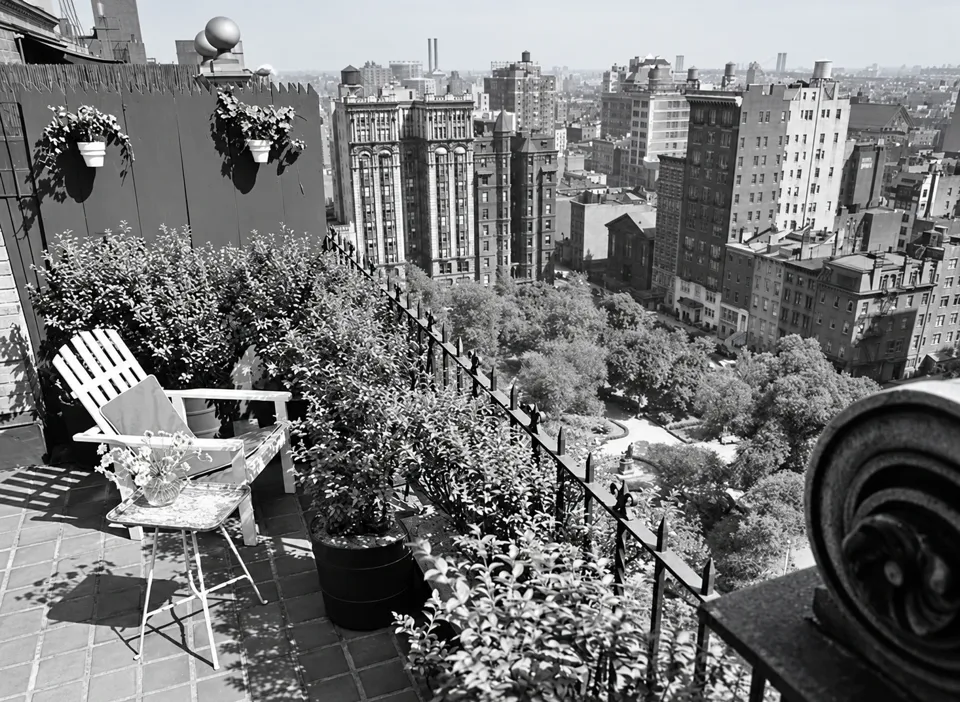 A planted terrace at 60 Gramercy Park North, with a chair, iron railing and Gramercy Park below.