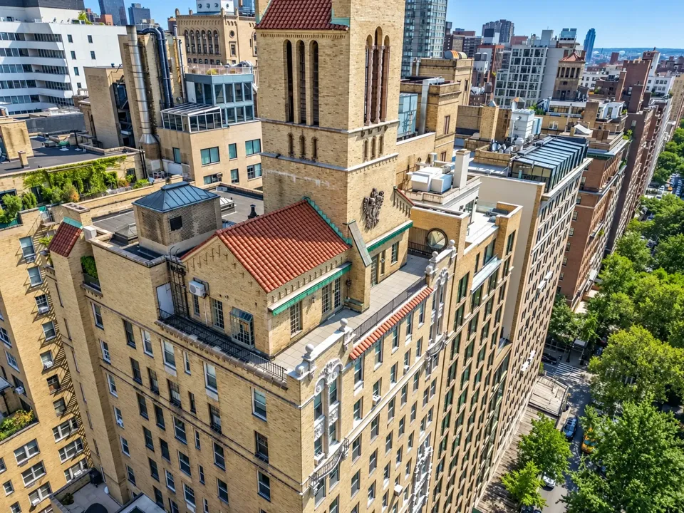 An elevated view of red-tiled roofs, terraces, the ornamental tower and the Park below.
