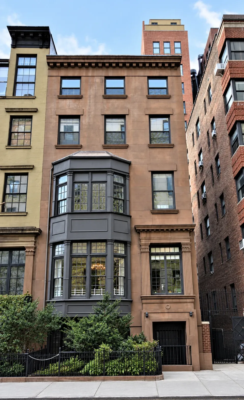 The brownstone façade of 9 Gramercy Park South, with a dark projecting bay, classical former doorway, and bracketed cornice.