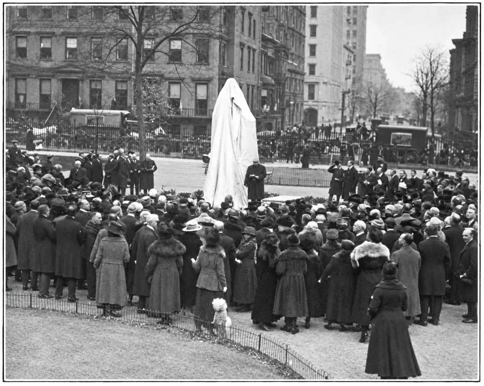 A crowd in coats and hats surrounds the still-covered Booth statue before its unveiling in 1918.