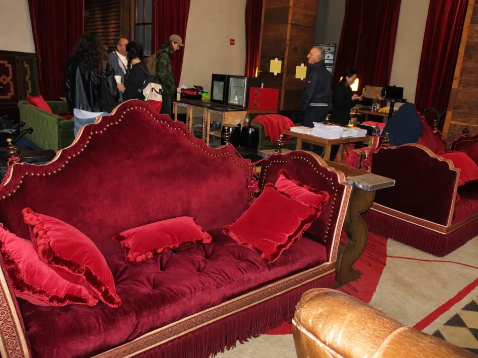 Red velvet seating and hotel furnishings inside the Gramercy Park Hotel during the 2022 liquidation sale, with visitors in the background.