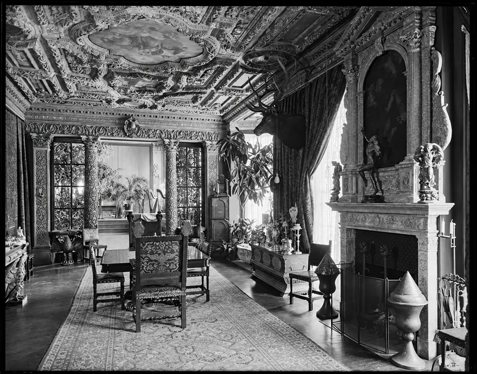 Stanford White’s dining room, with an ornate ceiling, fireplace, dining table and chairs.