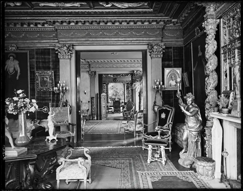 An interior view through adjoining rooms in Stanford White’s house, with paintings, sculpture and ornate furnishings.