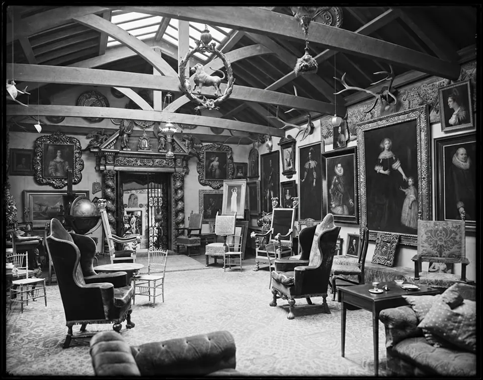 Stanford White’s picture gallery, with exposed roof beams, paintings and chairs.