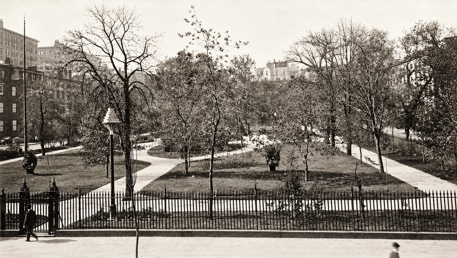 Historic postcard view across Gramercy Park, with branching paths, trees, iron gates, and the surrounding buildings.