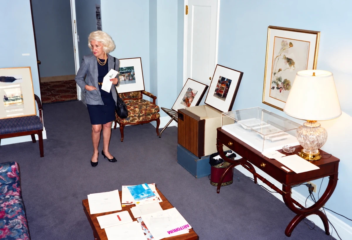 A visitor studies artworks arranged among the furnishings of a hotel bedroom at the 1994 fair.