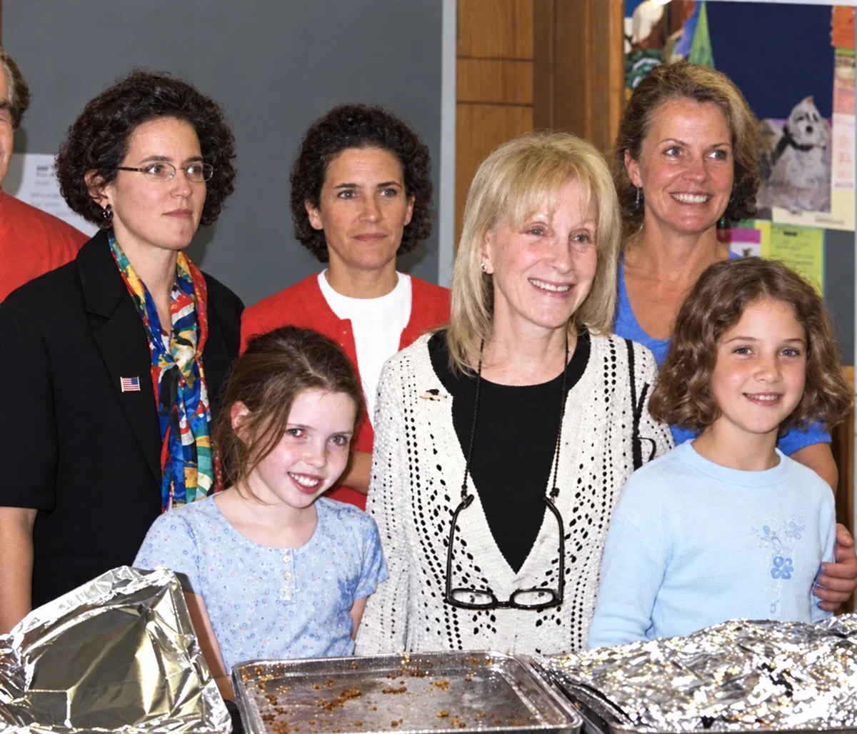 Adults and children gathered behind trays of prepared food during the 2001 relief effort.