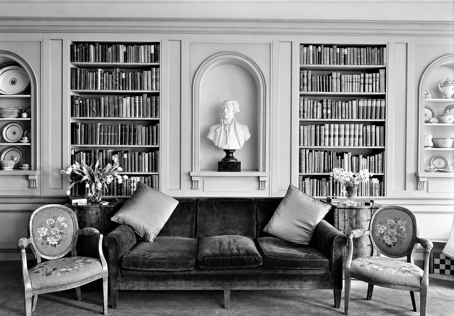 Bookcases flank a bust in an arched niche above a sofa in the Barlow apartment.