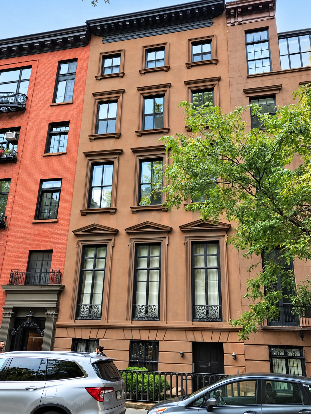 The brownstone façade of 11 Gramercy Park South, with three bays of windows, triangular parlor-window pediments, and a dark cornice.