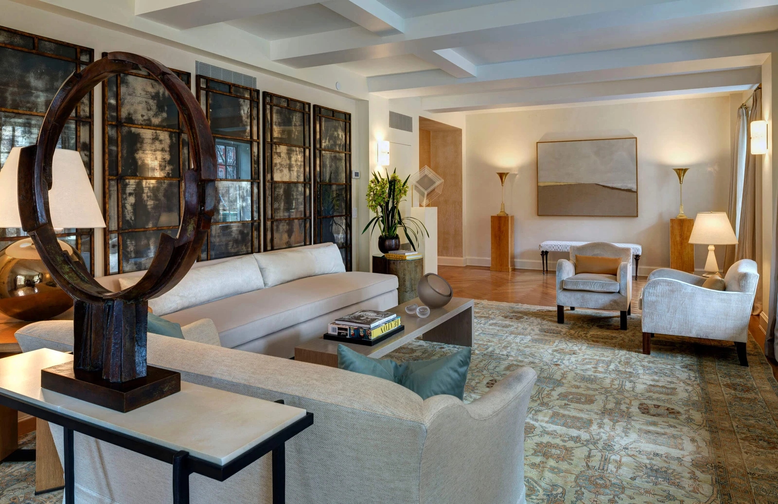 A living room in the converted 18 Gramercy Park South, with a long sofa, armchairs, artwork and broad windows.