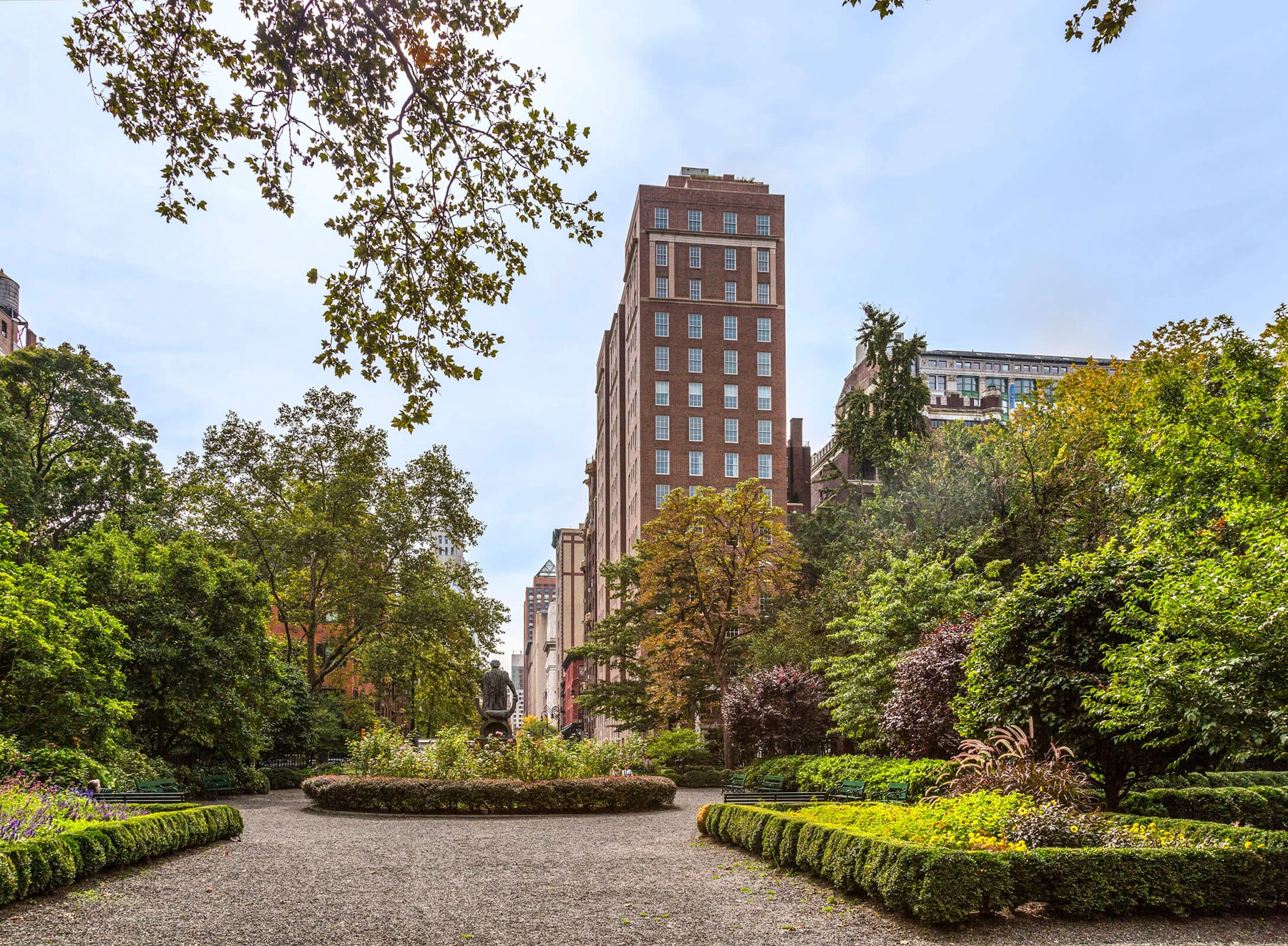 18 Gramercy Park South rising beyond the trees and paths of Gramercy Park.