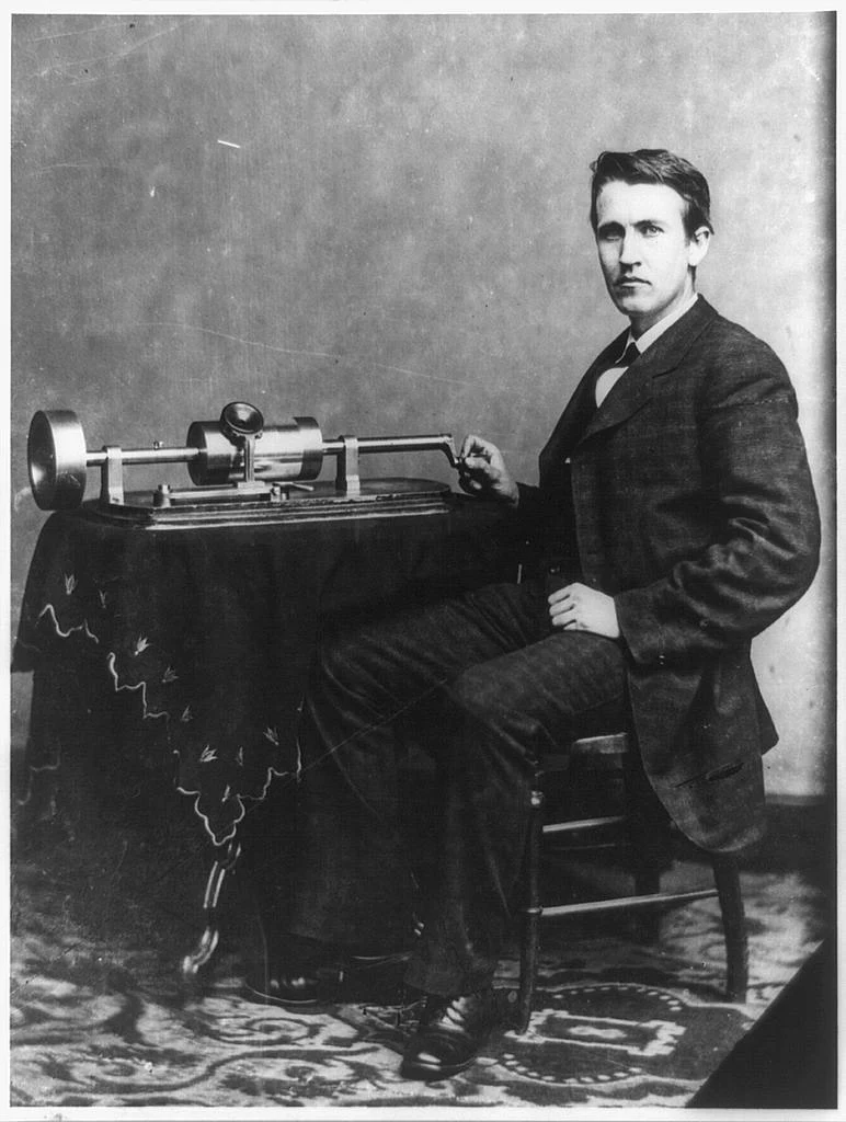 Thomas Edison seated beside a phonograph, circa 1878.