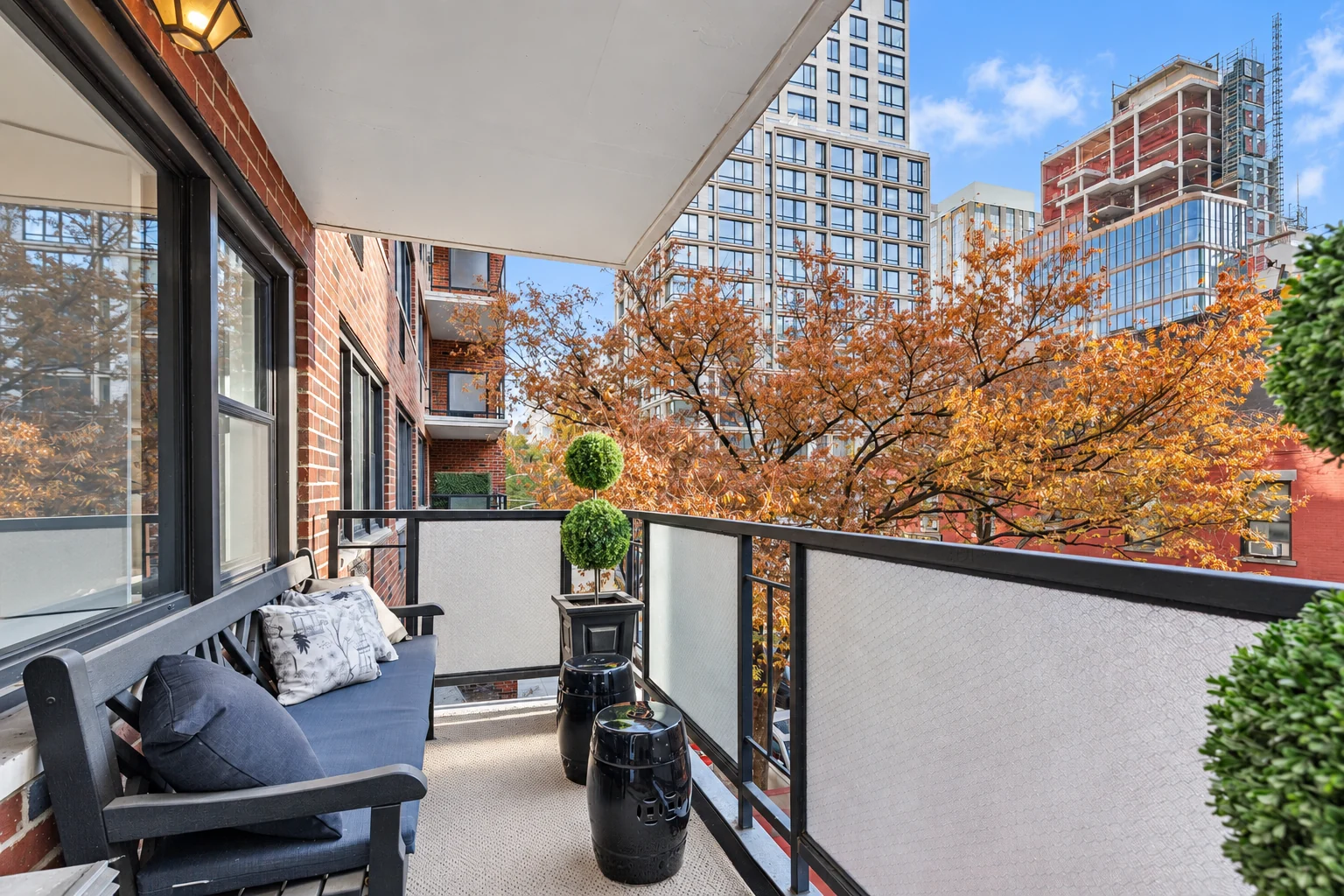 Balcony with a table and two chairs overlooking Gramercy Park and neighboring buildings, photographed in 2023.