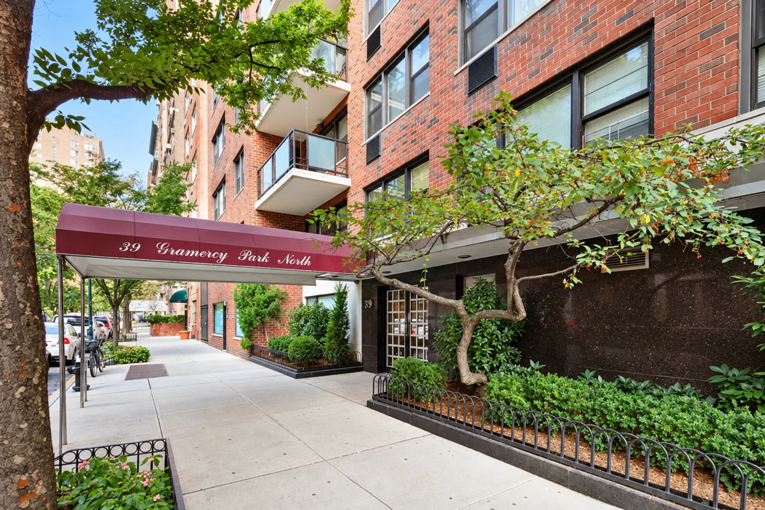 The maroon entrance canopy and pale stone base of 39 Gramercy Park North.