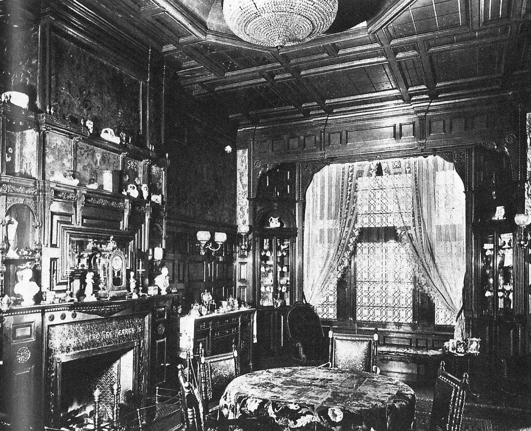 Historic black-and-white view of the Harper dining room with carved wood walls, an ornate ceiling, upholstered seating and display cabinets.