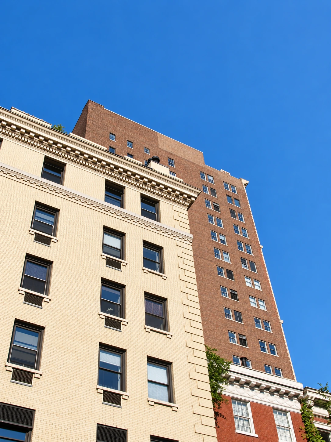 Upper stories of 7 Gramercy Park West with pale brick, stone corner blocks and an ornamental cornice.