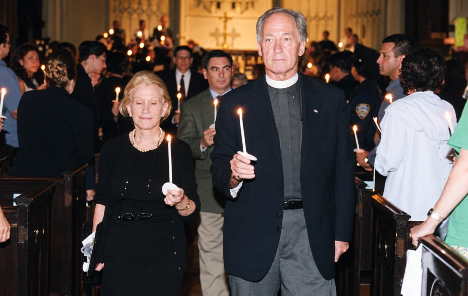 Arlene Harrison and the Rev. Thomas Pike holding candles among neighbors at Calvary Church.