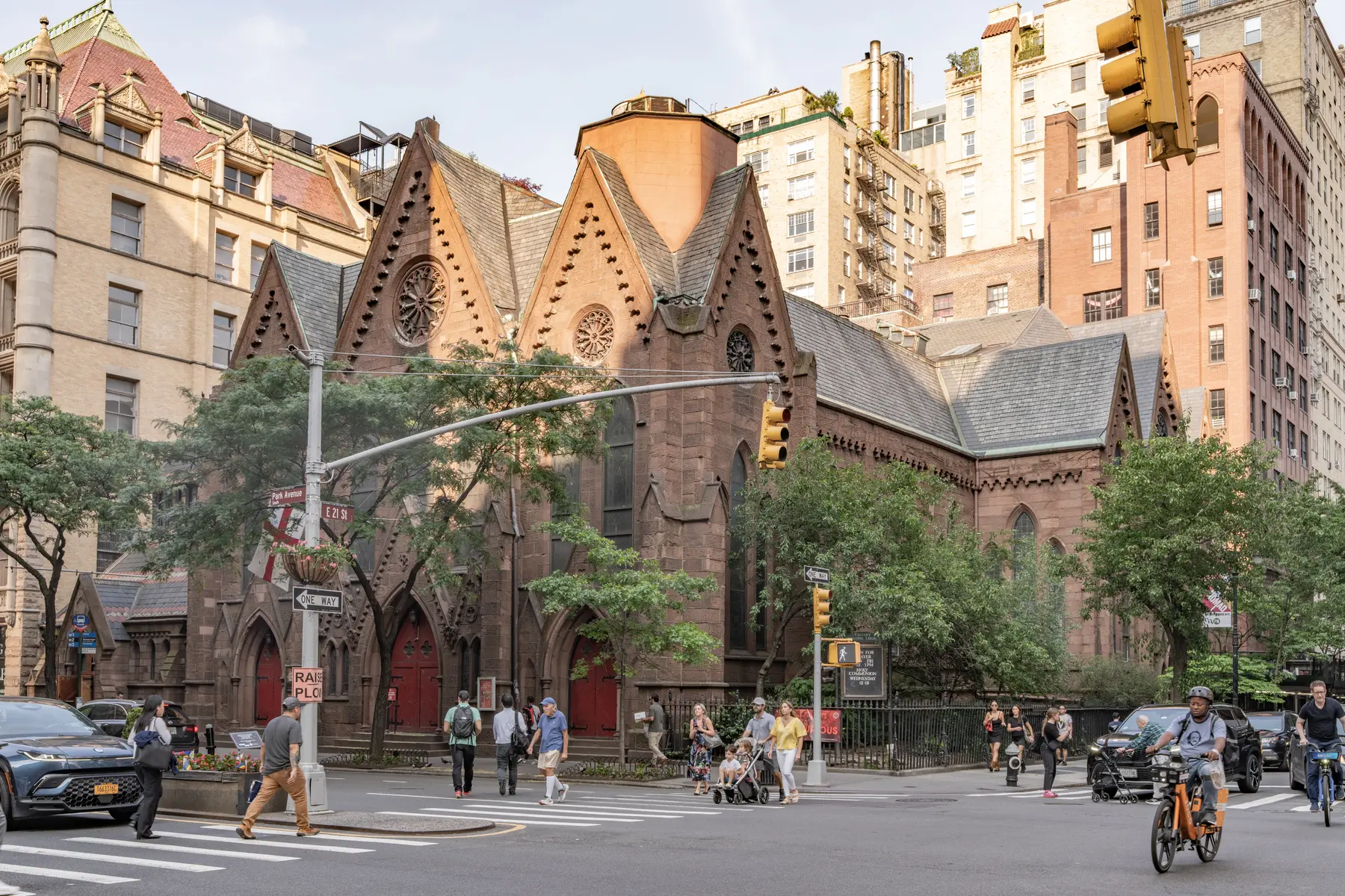 Calvary’s low brownstone Gothic church seen across Park Avenue South, with taller buildings behind it.