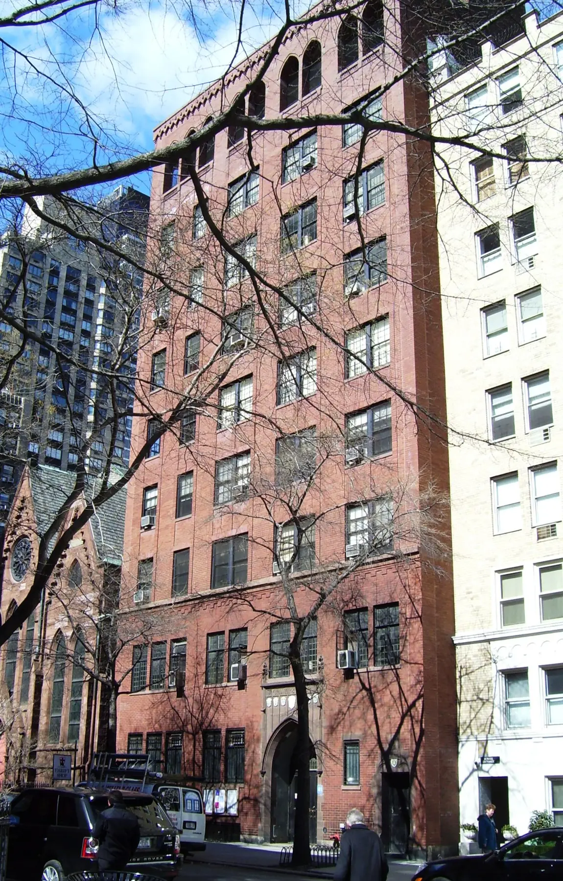 The tall brick facade of Calvary House, with grouped windows and a pointed stone entrance at street level.