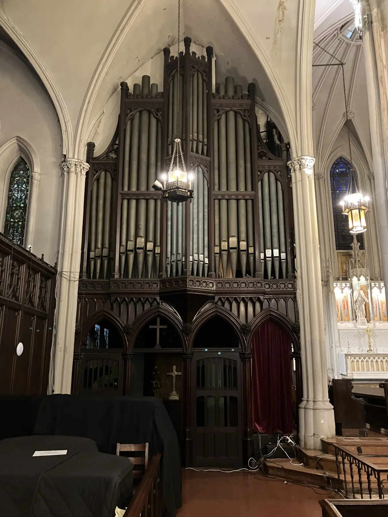 Tall organ pipes in a carved wooden case beneath Calvary’s pointed arches.