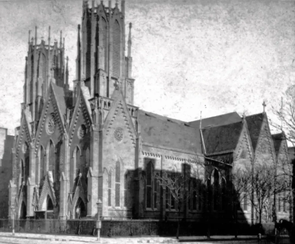 A historic street photograph of Calvary Church with its two shorter towers and neighboring buildings.