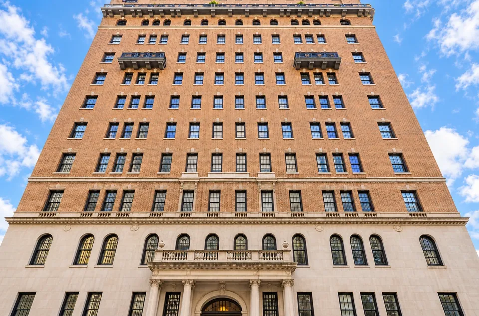 One Lexington Avenue’s brick and limestone façade in warm daylight, with its balconies and entrance stonework clearly visible.