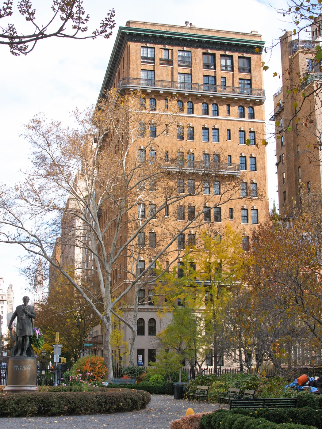 One Lexington Avenue rising above the trees on the north side of Gramercy Park, with the Edwin Booth statue at left.