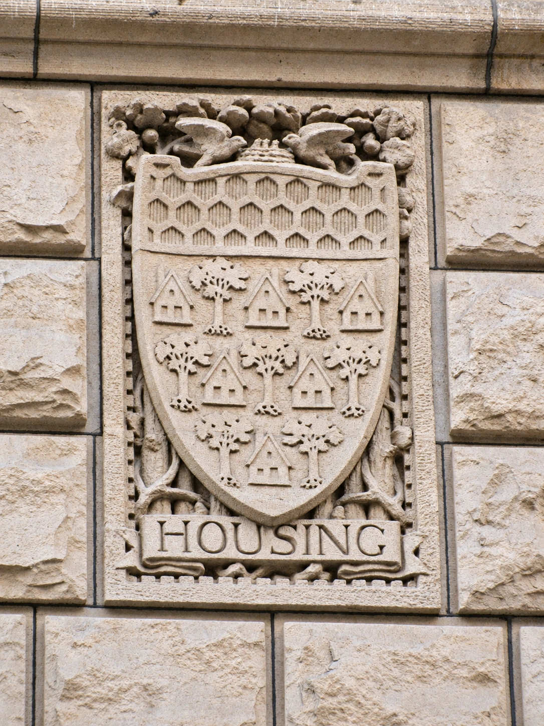 The Housing relief, with houses, trees, a honeycomb pattern and birds beside a nest.