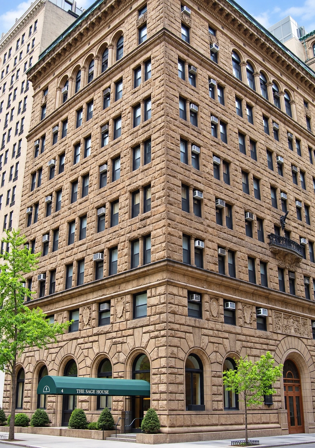 The corner of Sage House, showing its sandstone facades, paired windows and arcaded upper floors.