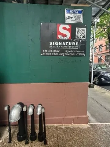 The construction wall with the purple graffiti painted over.