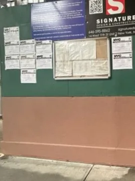 The construction wall with the teal graffiti painted over.