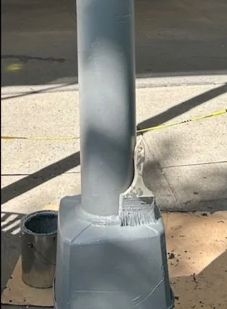 The lamppost base freshly painted gray.
