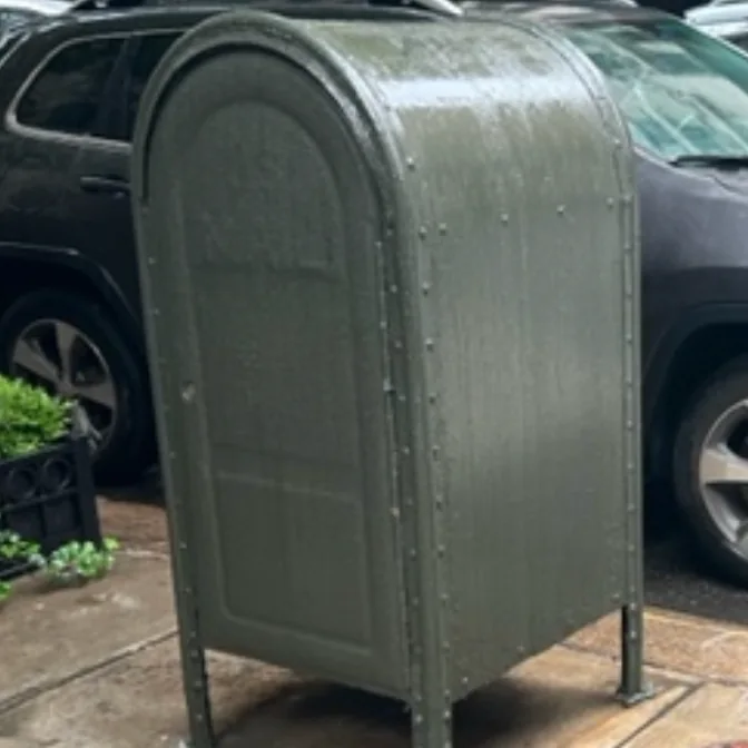 The green mail relay box with graffiti painted over.