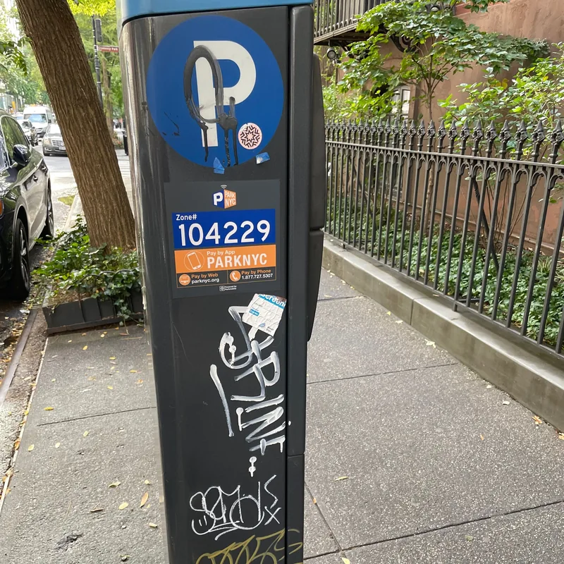 Graffiti and stickers on parking meter 104229.