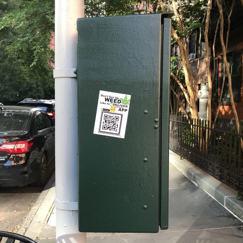 A sticker on a green traffic control box.