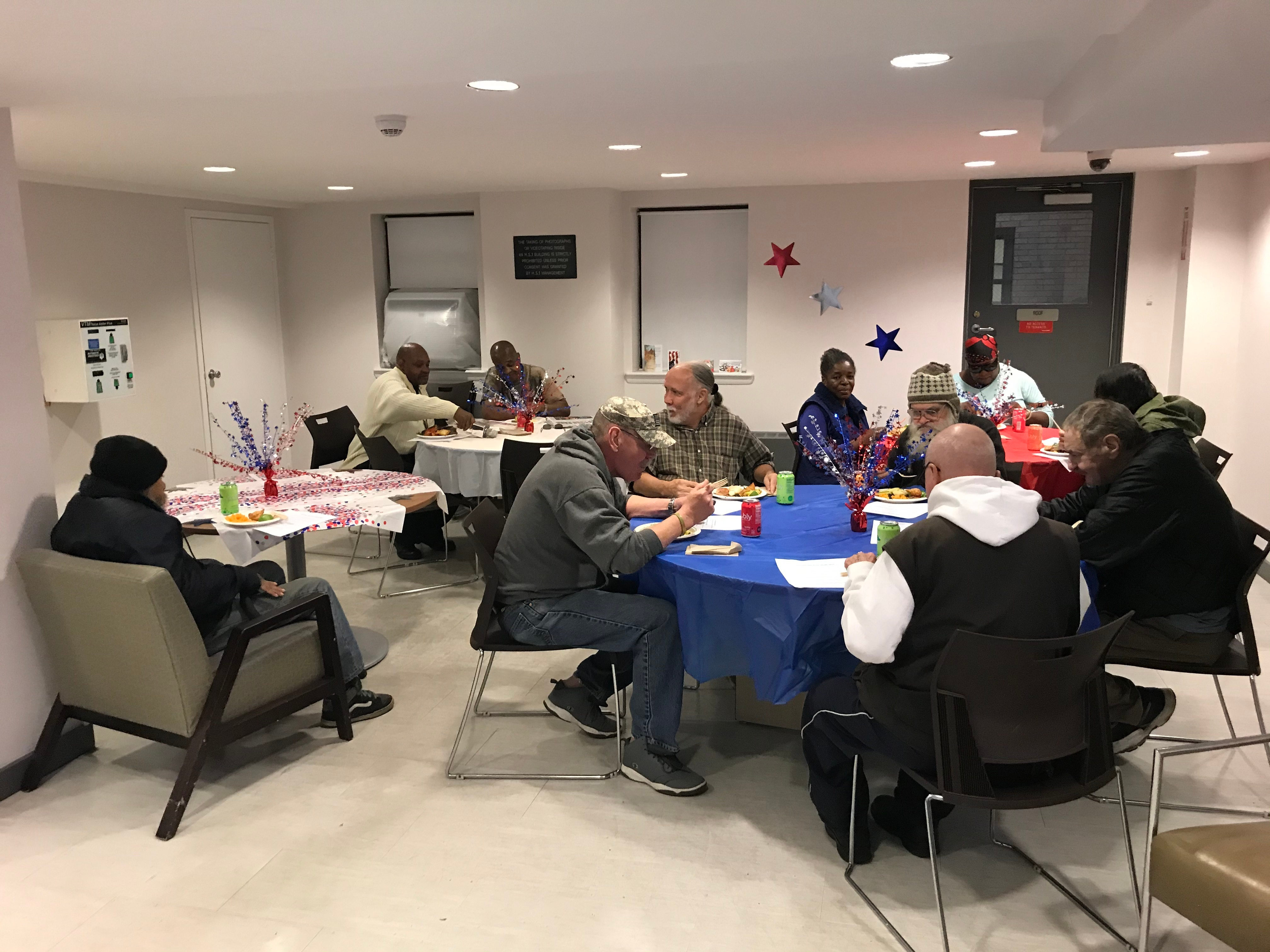 Luncheon guests sit around tables decorated with small American flags at Kenmore Hall.