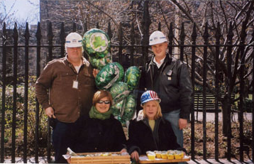 Two construction representatives and two neighbors gather beside the Park fence.
