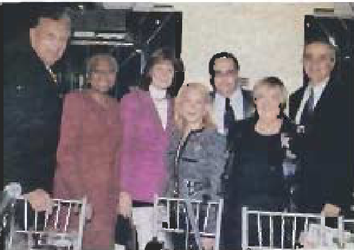Guests stand together at a luncheon table.