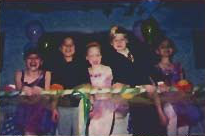 Children and costumed performers gather at a table during the ballet benefit.