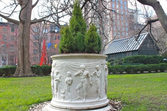 Evergreen plants fill the carved wellhead in winter.