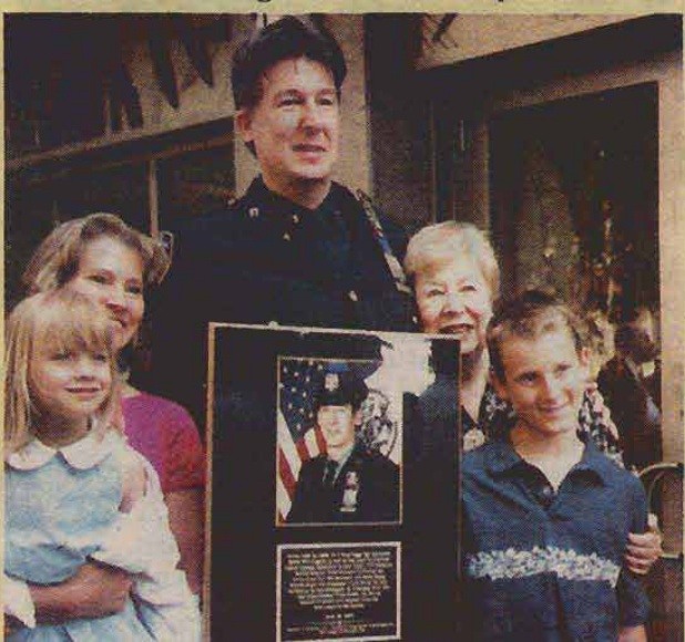 Scott Kimmins holds a recognition plaque with his family.