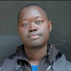 Portrait of Saliou Diop wearing a dark collared jacket.