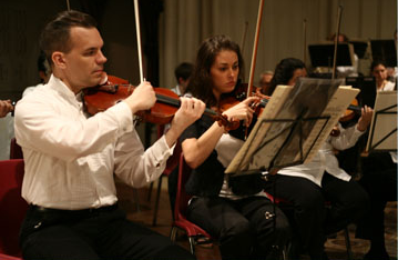 Violinists read from music stands during a performance inside Calvary Church.