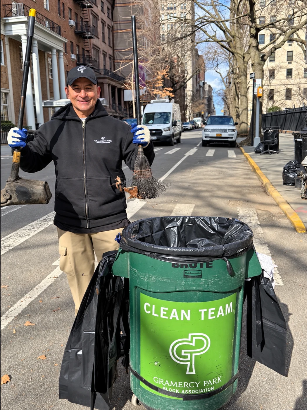 A member of the Block Association’s Clean Team with broom, dustpan and a green collection bin on Gramercy Park West.