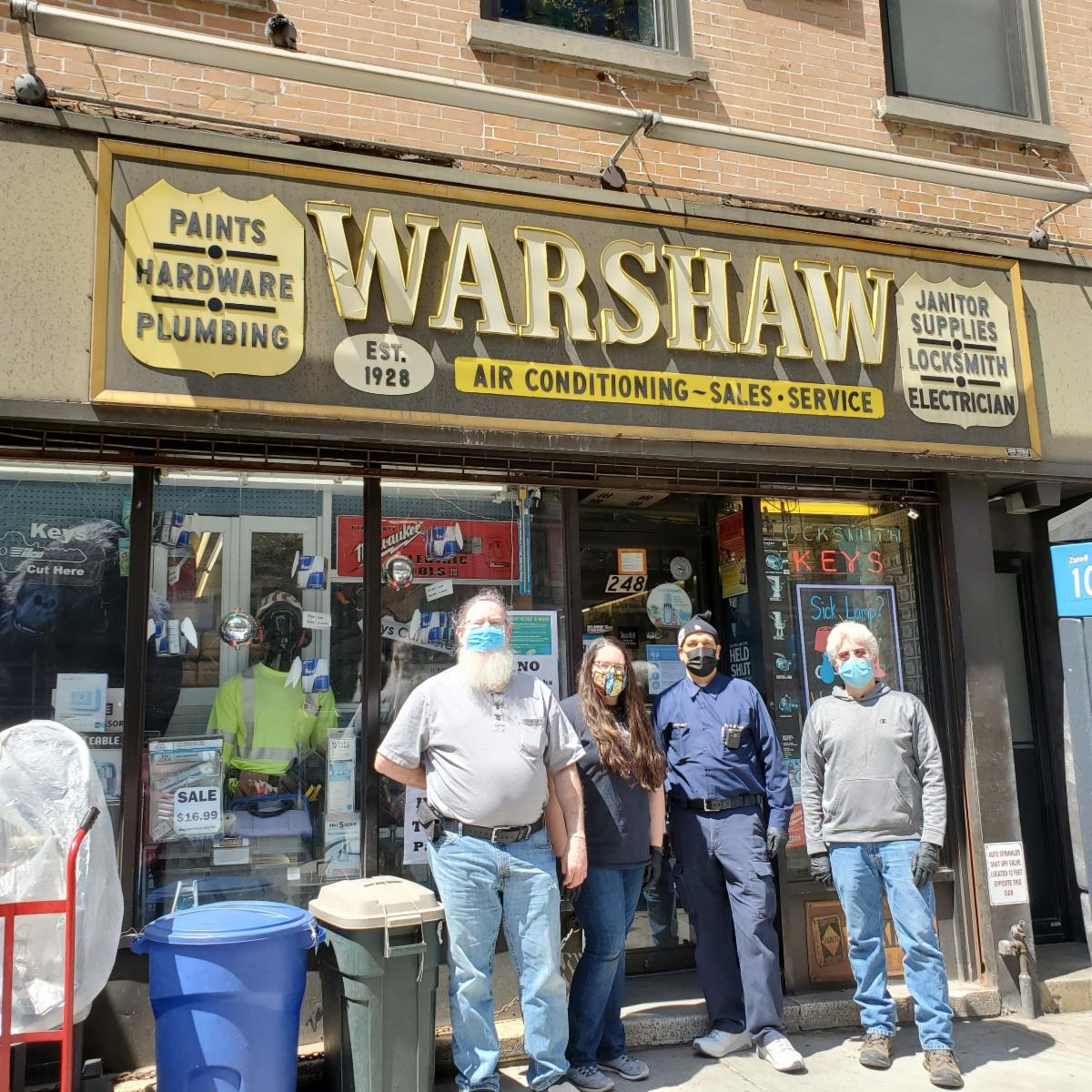 Four masked neighbors stand outside Warshaw Hardware.