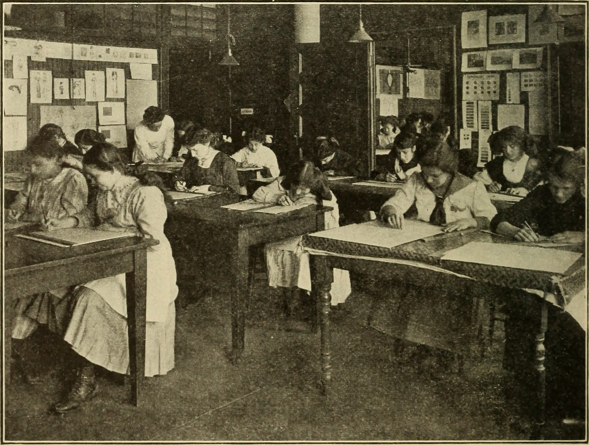 Students work at desks in a historical classroom photograph.